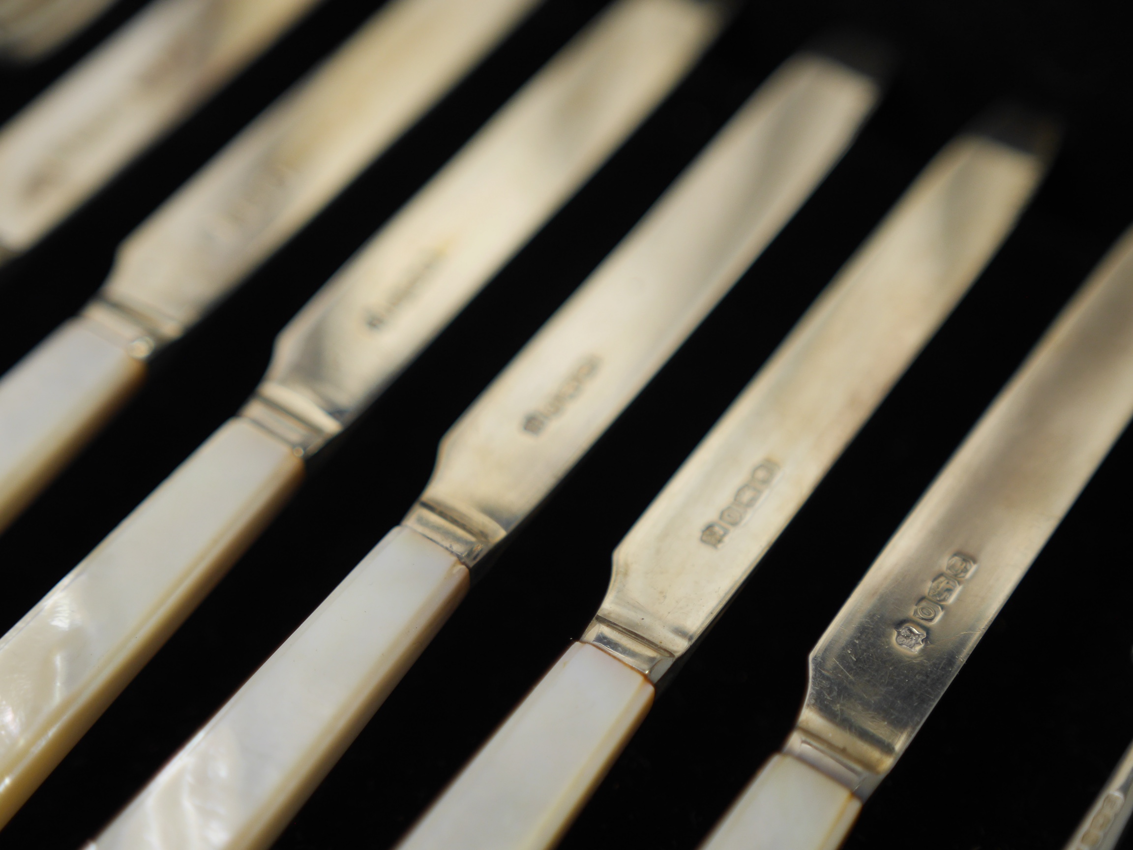 A cased set of six pairs of George V mother of pearl handled silver dessert eaters, by Thomas Bradbury & Sons, Sheffield, 1931, knife 17.5cm. Condition - fair to good